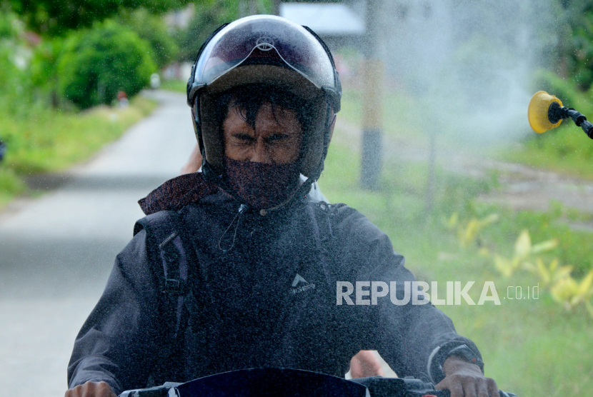Seorang warga disemprotkan cairan disinfektan saat akan memasuki pemukiman warga di Kabupaten Gowa, Sulawesi Selatan.