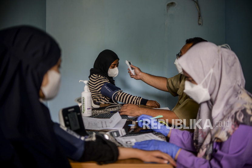 Tenaga kesehatan memeriksa kesehatan warga yang akan disuntik vaksin Covid-19 di RPTRA Taman Mandala, Tebet, Jakarta, Senin (29/11). Capaian vaksinasi Covid-19 di wilayah DKI Jakarta dosis pertama sudah mencapai 124,1 persen atau 11.091.875 orang dan dosis kedua 100,5 persen atau 8.987.124 orang. Dengan rincian penerima vaksin 70 persen warga ber-KTP DKI Jakarta dan non KTP DKI Jakarta 30 persen.  Republika/Putra M. Akbar