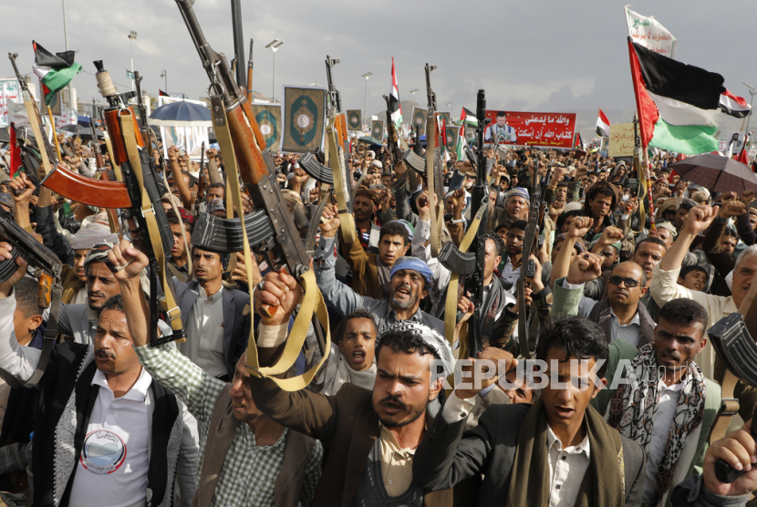 Pendukung Houthi membawa senapan mesin dan bendera Palestina dalam unjuk rasa menentang serangan AS terhadap Yaman di Sanaa, Jumat, 17 Mei 2024.