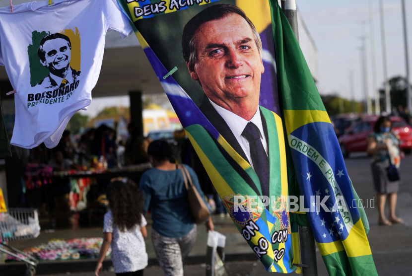 Bendera dengan gambar kampanye Presiden Brasil Jair Bolsonaro, yang merupakan kandidat untuk pemilihan kembali, ditampilkan untuk dijual di dekat tempat pekerja publik federal memprotes pemotongan gaji, di Brasilia, Brasil, Selasa, 2 Agustus 2022.