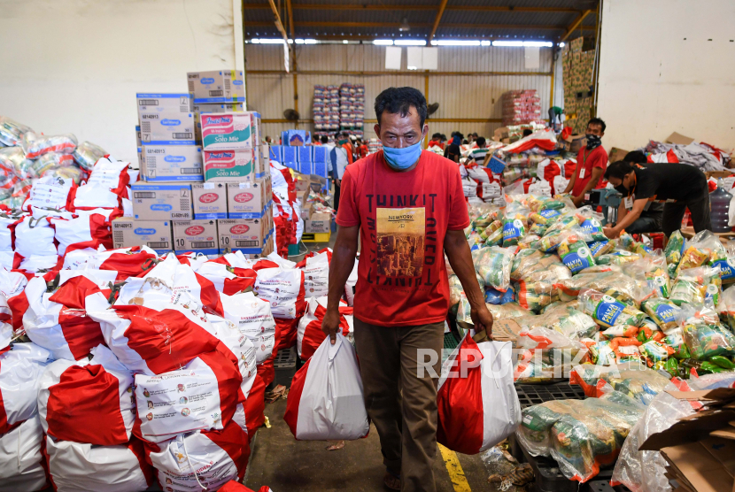 Pekerja membawa paket bantuan sosial (bansos) yang akan disalurkan di Gudang Food Station Cipinang, Jakarta, Rabu (22/4/2020). Pemerintah menyalurkan paket bansos masing-masing sebesar Rp600 ribu per bulan selama tiga bulan sebagai upaya untuk mencegah warga tidak mudik dan meningkatkan daya beli selama pandemi COVID-19 kepada warga yang membutuhkan di wilayah Jabodetabek