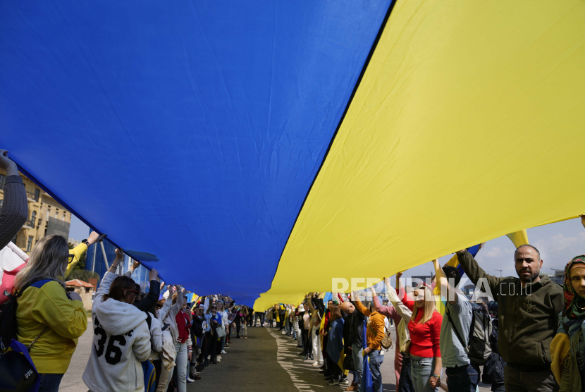 Warga Ukraina yang tinggal di Lebanon mengibarkan warna bendera nasional mereka, selama protes menentang invasi Rusia ke negara mereka, di Beirut, Lebanon, Ahad, 27 Maret 2022