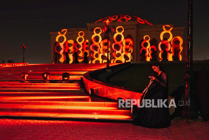  Seorang pemain biola bersiap untuk pertunjukan saat University City Hill duduk bermandikan cahaya sebagai bagian dari Festival Cahaya Sharjah tahunan di Sharjah, Uni Emirat Arab, Rabu, 9 Februari 2022. Sharjah Gelar Festival Cahaya Selama 12 Hari
