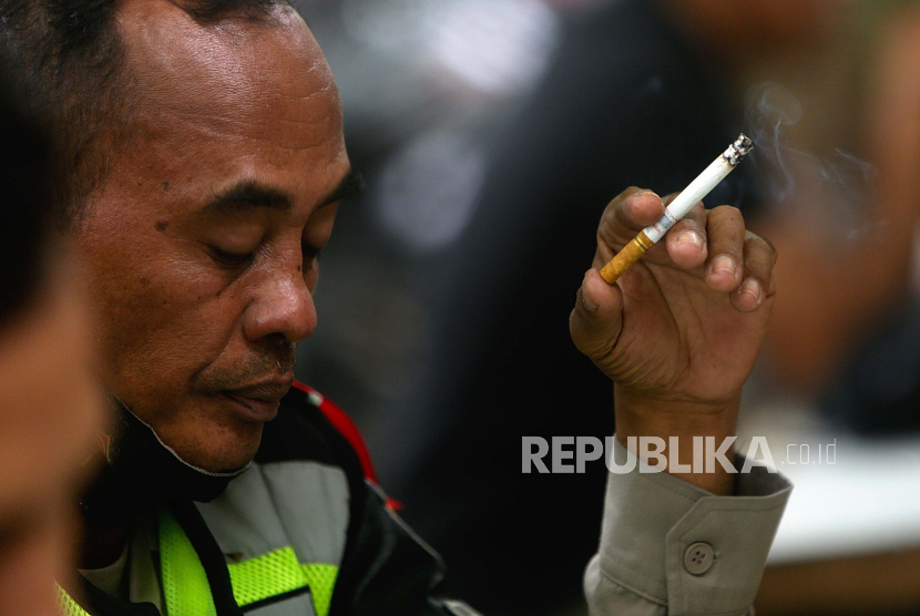 Seorang pria merokok di sebuah jalan di Jakarta, Indonesia.  Polemik pelarangan penjualan rokok batangan yang diwacanakan pemerintah mendapat perhatian dari sejumlah akademisi. Sebagai solusinya, edukasi sosial dinilai berperan penting.