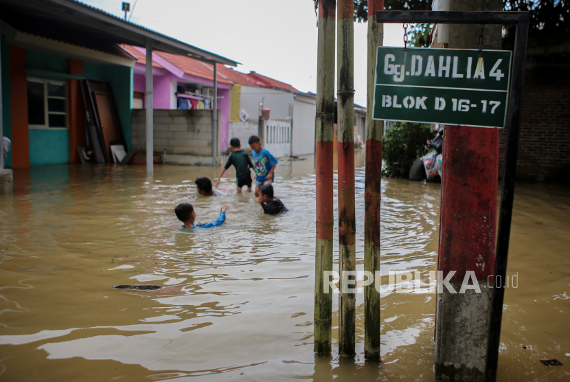 Sejumlah bocah bermain di kawasan banjir,  di Tigaraksa, Kabupaten Tangerang, Banten, Selasa (9/2/2021). Banjir setinggi hingga 90 cm  tersebut terjadi akibat luapan kali Cimanceuri. 