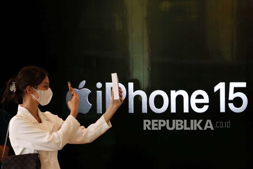 A customer using a mobile phone takes a photograph of the new iPhone 15 after buying at the Apple Store in Bangkok, Thailand, 22 September 2023. Apple Inc
