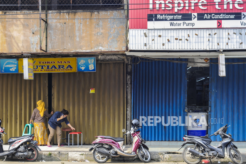 Warga berada di depan pertokoan yang tutup di Bekasi, Jawa Barat, Ahad (19/4/2020). Pemerintah kabupaten Bekasi memperpanjang status Pembatasan Sosial Berskala Mikro (PSBM) hingga 20 Januari 2021.