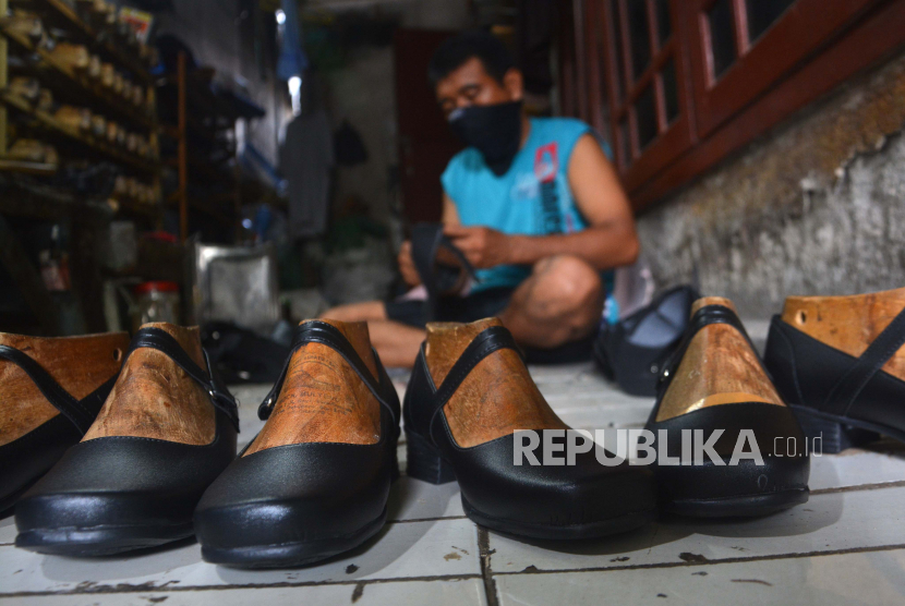 Seorang pekerja menyelesaikan pembuatan sepatu di industri rumahan Surodinawan, Prajuritkulon, Kota Mojokerto, Jawa Timur, Jumat (26/6/2020). Sekitar 50 persen pelaku Usaha Mikro Kecil Menengah (UMKM) diperkirakan gulung tikar, akibat pandemi Covid-19. 