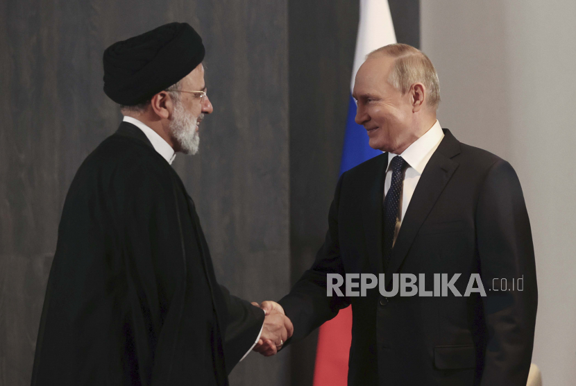 Presiden Rusia Vladimir Putin, kanan, dan Presiden Iran Ebrahim Raisi berjabat tangan. Rusia, Iran, dan beberapa negara wilayah Eurasia bentuk zona perdagangan bebas