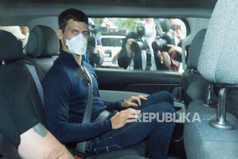 Petenis Serbia Novak Djokovic (tengah) meninggalkan fasilitas penahanan pemerintah Park Hotel sebelum menghadiri sidang pengadilan di kantor pengacaranya di Melbourne, Australia, 16 Januari 2022. 