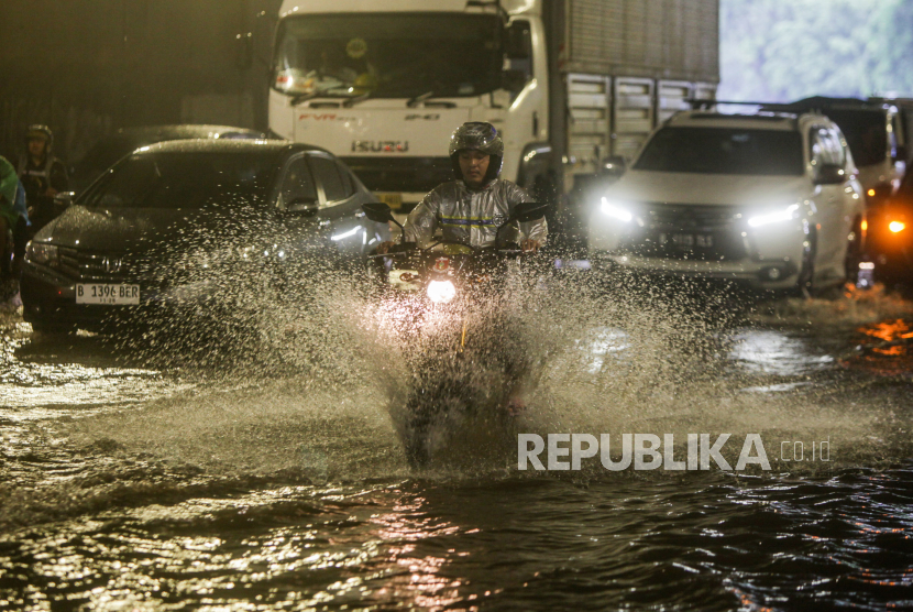 Pengendara motor melewati genangan air di Jalan DI Pandjaitan, Makasar, Jakarta Timur, Senin (5/2/2024). Hujan deras yang mengguyur Jakarta membuat dua ruas Jalan DI Pandjaitan yang berada di Kecamatan Makasar dan Jatinegara tergenang air sehingga mengakibatkan kemacetan.