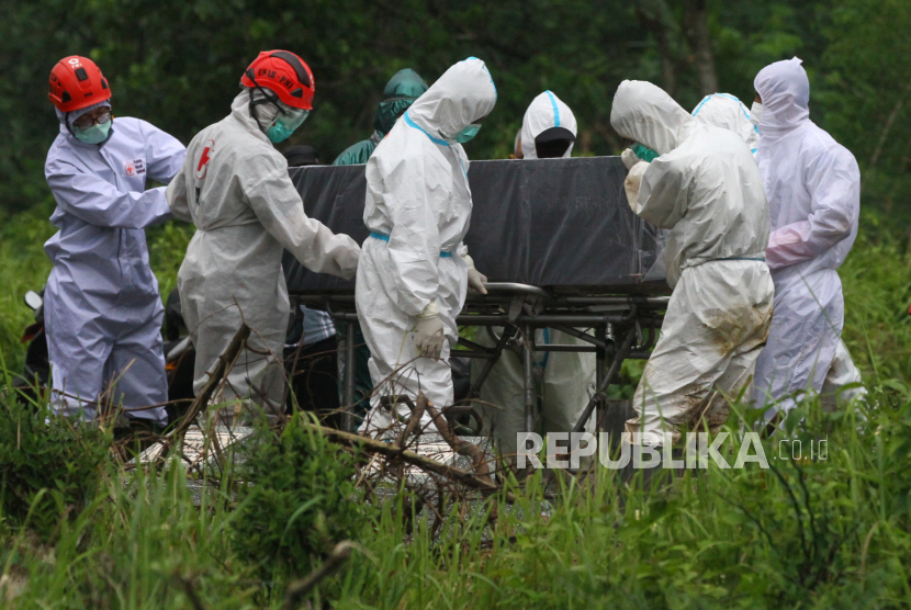 Petugas yang mengenakan APD memakamkan jenazah pasien COVID-19. TPU Srengseng Sawah di Jagakarsa, Jaksel, mulai digunakan sebagai makam jenazah virus coron jenis baru.
