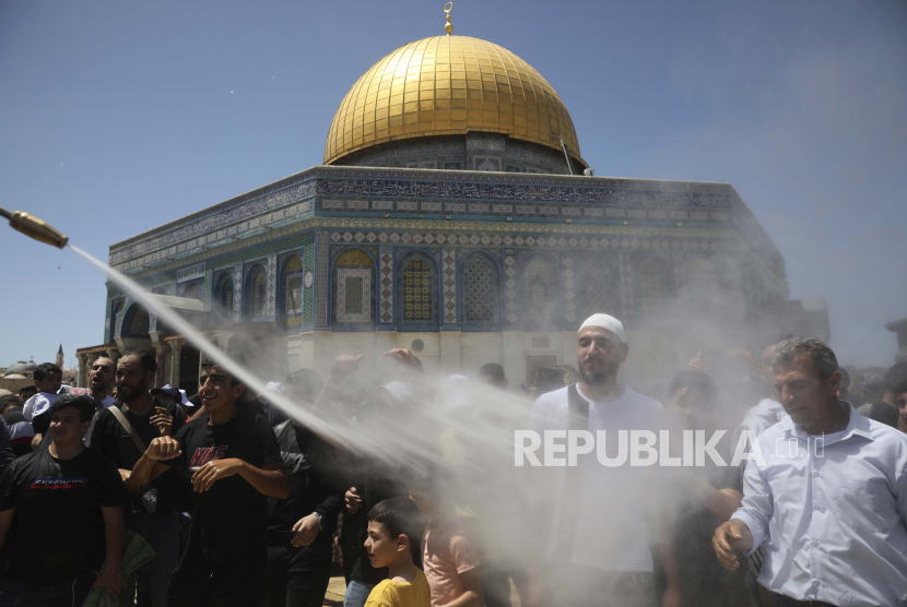 Jamaah didinginkan dengan kabut pada sholat Jumat terakhir bulan suci Ramadhan di Masjid Dome of the Rock di kompleks Masjid Al Aqsa di Kota Tua Yerusalem, Yerusalem, Jumat, 7 Mei 2021.