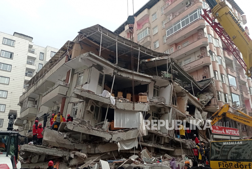 Petugas mencari korban di lokasi bangunan yang runtuh setelah gempa  bumi dahsyat di Diyarbakir, tenggara Turki, Senin (6/2/2023).  Menurut US Geological Service, gempa berkekuatan awal 7,8 melanda Turki selatan dekat perbatasan Suriah . 