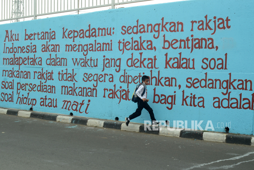 Seorang anak melintasi mural bertema pidato Bung Karno di dinding flyover Jalan Bekasi Timur Raya, Jakarta Timur, Jumat (12/8/2022). Mural tersebut dibuat untuk mengingat pidato Bung Karno di Bogor tahun 1952 sekaligus mengenang Haji Darip seorang pejuang kemerdekaan dan ulama Indonesia saat mempertahankan wilayah Klender di masa kemerdekaan tahun 1945. 