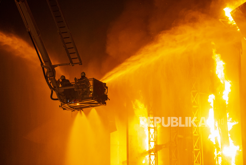 Petugas pemadam kebakaran menyemprotkan air ke arah api yang membakar gedung utama Kejaksaan Agung di Jakarta, Minggu (23/8/2020) dini hari. Kebakaran tersebut masih dalam penanganan pihak pemadam kebakaran. ANTARA FOTO/Aditya Pradana Putra/wsj. 