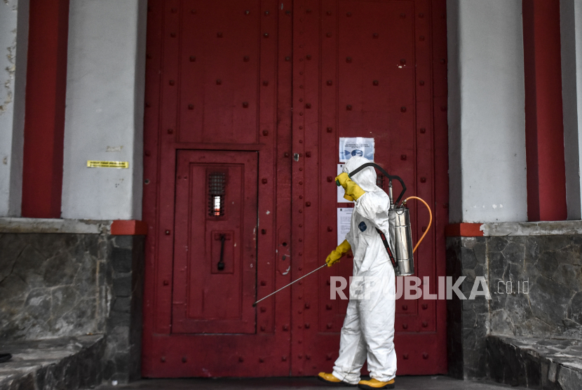 Petugas dari Palang Merah Indonesia (PMI) Kota Bandung menyemprotkan cairan disinfektan di pintu masuk Lapas Sukamiskin, Kota Bandung, Senin (23/3/2020). 