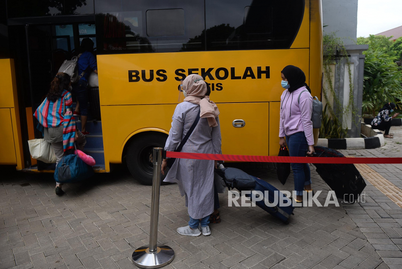 Sejumlah pasien COVID-19 menaiki bus Sekolah yang akan membawa mereka menuju Rumah Sakit Darurat Wisma Atlet di Puskesmas Kecamatan Duren Sawit, Jakarta, Senin (30/11). Menurut petugas Puskesmas Duren Sawit, sebanyak 20 pasien COVID-19 dibawa menuju Wisma Atlet untuk menjalani isolasi mandiri.Prayogi/Republika.