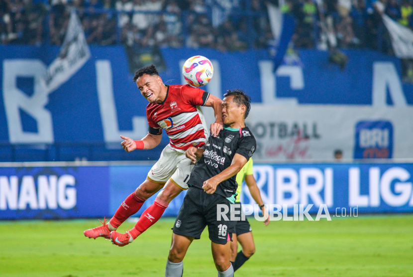 Pesepak bola Persib Bandung Adam Alis (kanan) berebut bola dengan pesepak bola Madura Luis Lulinha (kiri) saat menjalani pertandingan BRI Liga 1 di Stadion Gelora Bandung Lautan Api (GBLA), Bandung, Jawa Barat, Sabtu (22/2/2025). Pertandingan tersebut berlangsung imbang dengan skor 0-0. 