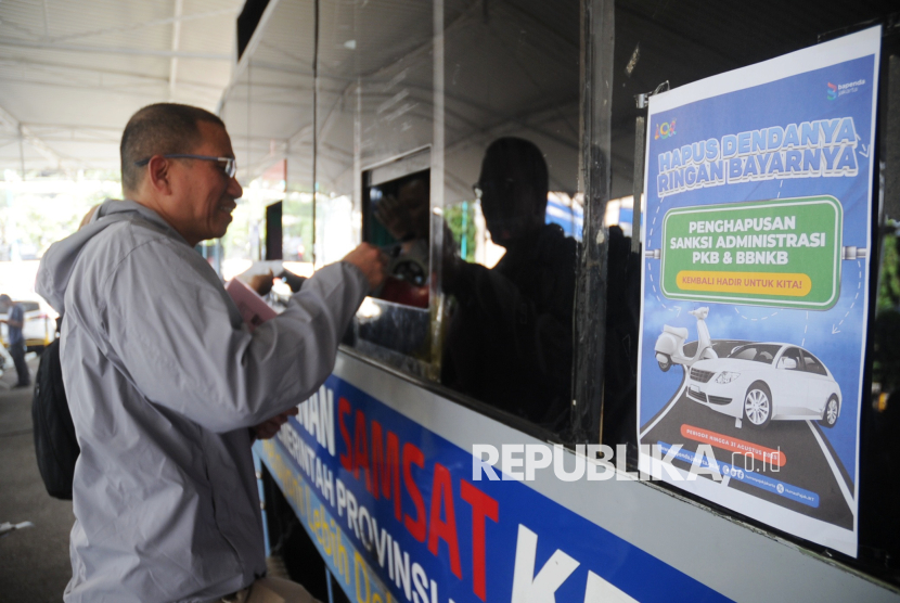 Warga melakukan pembayaran pajak kendaraan bermotor di lokasi layanan Samsat Keliling, Polda Metro Jaya, Jakarta, Selasa (17/6/2025). Pemerintah Provinsi DKI Jakarta memberlakukan program pemutihan pajak kendaraan bermotor dan bea balik nama kendaraan (BBNKB) dalam rangka HUT ke-498 Jakarta. Program ini berlangsung selama tiga bulan, mulai dari 14 Juni hingga 31 Agustus 2025. Program ini ditujukan untuk memberikan keringanan kepada masyarakat yang memiliki tunggakan pajak, serta meningkatkan kepatuhan dan kesadaran perpajakan.
