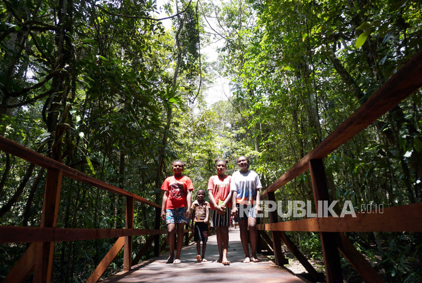 Anak-anak berjalan di jembatan sepanjang 3.250 meter di kawasan Hutan Klaso menuju Kampung Klagufuk Malaumkarta, Kabupaten Sorong, Papua Barat, Selasa (16/3/2021). 