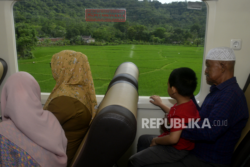 Sejumlah warga menikmati pemandangan pematang sawah saat menaiki kereta api di lintasan Kabupaten Maros-Barru, Sulawesi Selatan, Selasa (10/1/2023). 