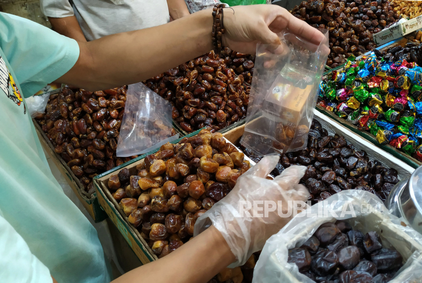 Pedagang kurma melayani pembeli di Pasar Baru, Kota Bandung, Jawa Barat, Senin (18/3/2024). Kenali ciri-ciri kurma yang masih segar.