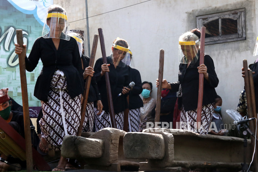 Warga Suku Osing memainkan musik tradisional gedhogan (lesung) pada Festival Musik Lesung di Desa Adat Kemiren, Banyuwangi, Jawa Timur, Ahad (11/4/2021). Musik lesung yang dimainkan dengan pukulan alu dan diiringi alunan angklung itu merupakan warisan leluhur Suku Osing sebagai tradisi saat panen tiba. 