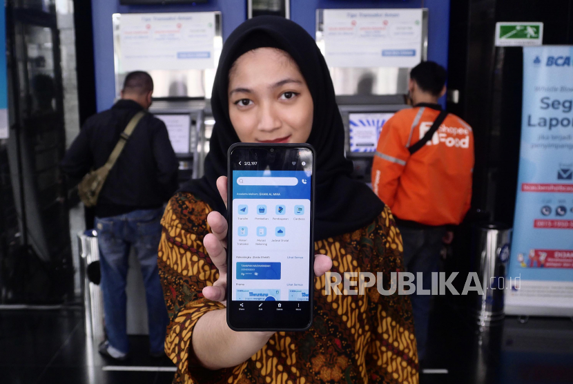 Nasabah menunjukkan aplikasi mobile banking BCA Syariah di ATM BCA di Jakarta, Kamis (11/5/2023). 