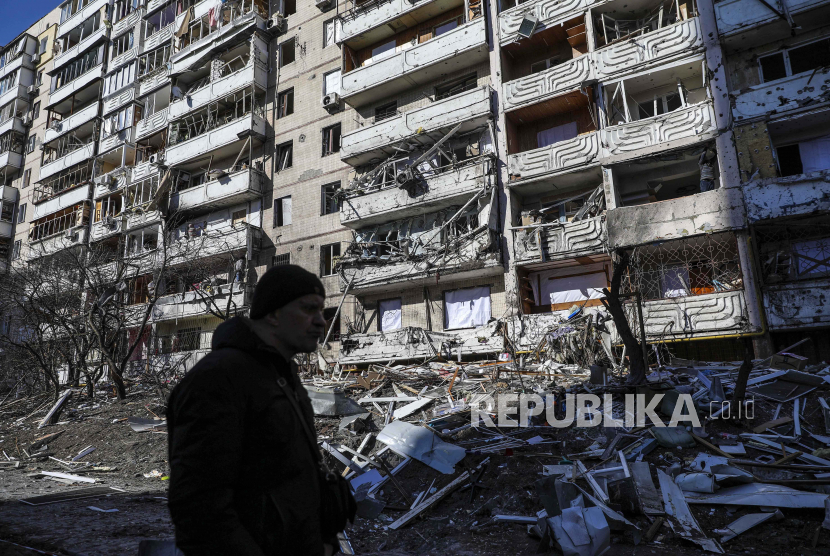  Seorang pria melewati puing-puing sebuah bangunan yang rusak akibat penembakan di Kyiv, Ukraina, 15 Maret 2022. Perang Perang menghancurkan perbaikan ekonomi yang sudah berlangsung selama dua dekade.
