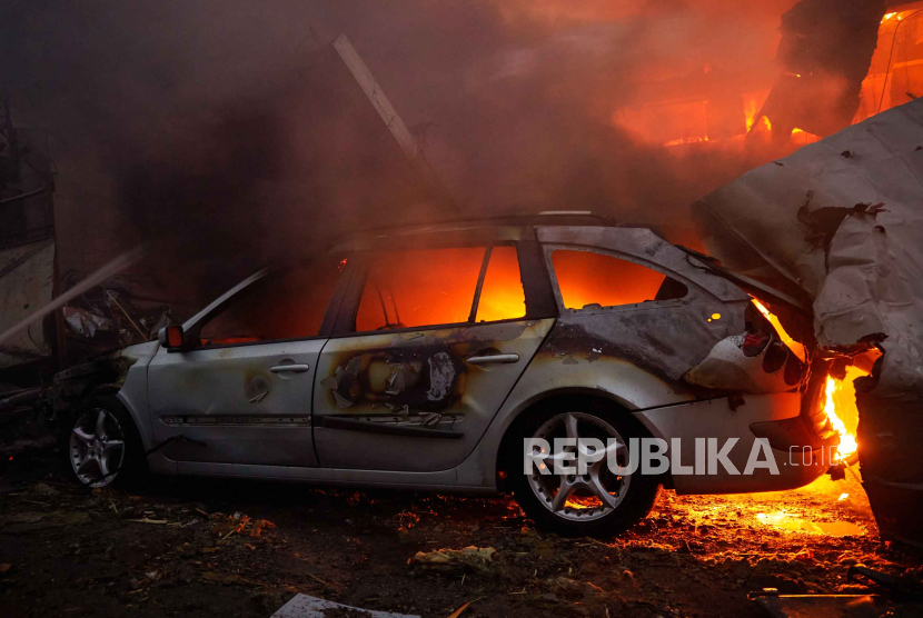 Sebuah mobil terbakar di lokasi jatuhnya rudal Rusia yang menargetikan ibu kota Kyiv, Ukraina, Rabu (30/8/2023). Pasukan Rusia melancarkan serangan dengan target ibu kota Ukraina Kyiv.