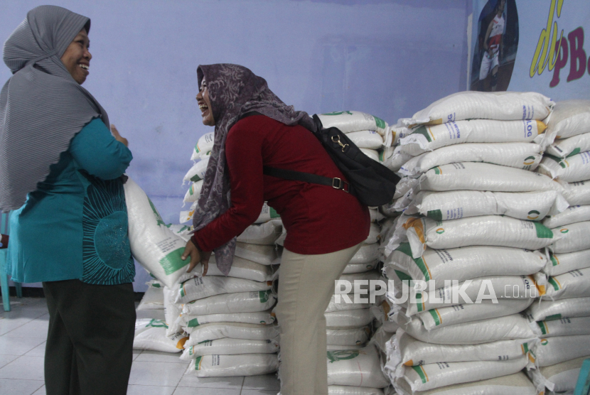 Relawan menyalurkan beras bantuan pangan tahap ketiga kepada masyarakat.