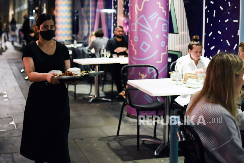 Pelayan membawakan makan di sebuah restoran di Soho, London, Selasa (22/9). Ilustrasi.