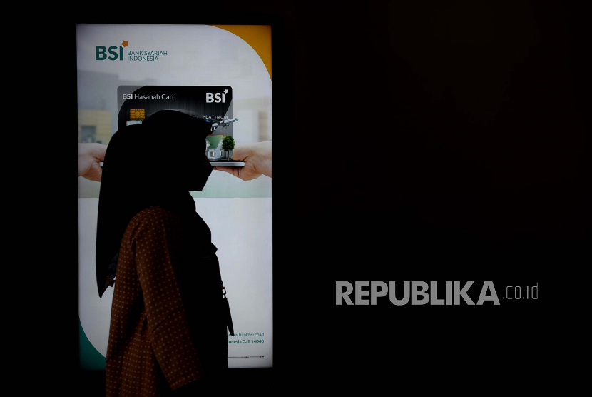 Nasabah melintas di papan informasi produk di Outlet Bank Syariah Indonesia (BSI) KC Jakarta Barat, Senin (1/2). Komite Stabilitas Sistem Keuangan (KSSK) sedang mengkaji kebijakan yang bisa mendorong penurunan suku bunga kredit perbankan. 