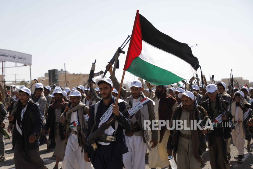 Milisi Houthi berparade di Provinsi Amran, Yaman, membawa bendera Palestina.