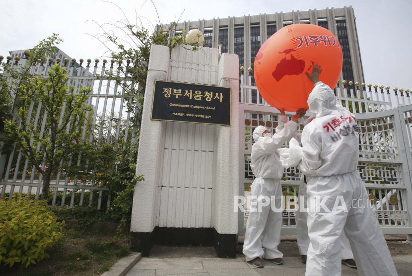  Aktivis lingkungan dengan balon bumi melakukan aksi mati-matian dalam unjuk rasa memperingati Hari Bumi melawan perubahan iklim di depan Kompleks Pemerintah di Seoul, Korea Selatan, Kamis, 22 April 2021.