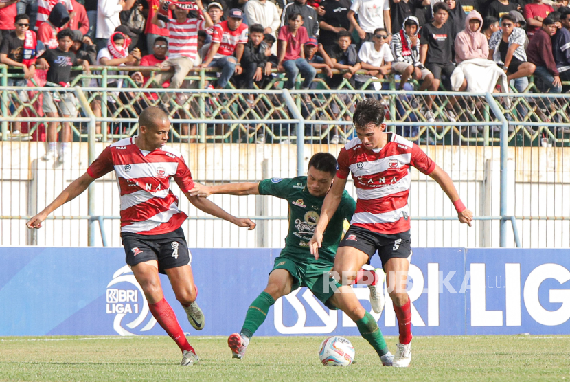 Pesepak bola Persebaya Surabaya Sho Yamamoto (tengah) berupaya melewati adangan pemain Madura United Cleberson Martins (kiri) dan Jacob Mahler pada Liga 1 di Bangkalan, Jawa Timur, Ahad (17/9/2023). 