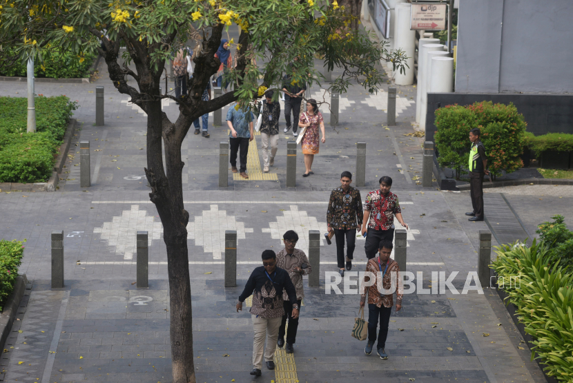 Sejumlah karyawan perkantoran mengenakan batik saat berjalan di kawasan Pedestrian Sudirman, Jakarta, Rabu (2/10/2024). Pengamat menilai kesadaran finansial di kalangan kelas menengah masih rendah. 