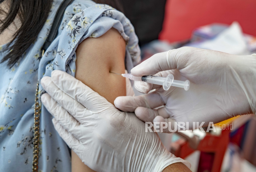  Seorang petugas kesehatan disuntik dengan vaksin COVID-19 di sebuah rumah sakit di Denpasar, Bali, Indonesia, 14 Januari 2021. Indonesia memulai program vaksinasi COVID-19 untuk petugas kesehatan medis dan pejabat tinggi pemerintah mulai 14 Januari 2021, sebagai a langkah awal program vaksinasi nasional di Indonesia.
