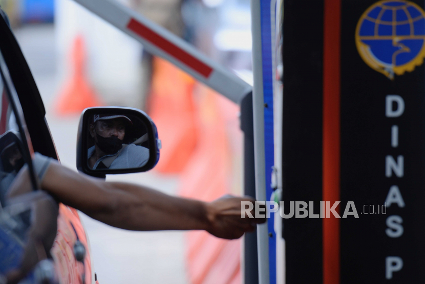 Warga mengambil tiket parkir kendaraan di Lapangan Parkir IRTI Monas, Jakarta, Sabtu (4/2/2023). Kementerian Lingkungan Hidup dan Kehutanan (KLHK) melakukan kegiatan uji emisi sebanyak 250 unit kendaraan bermotor baik roda dua maupun empat.