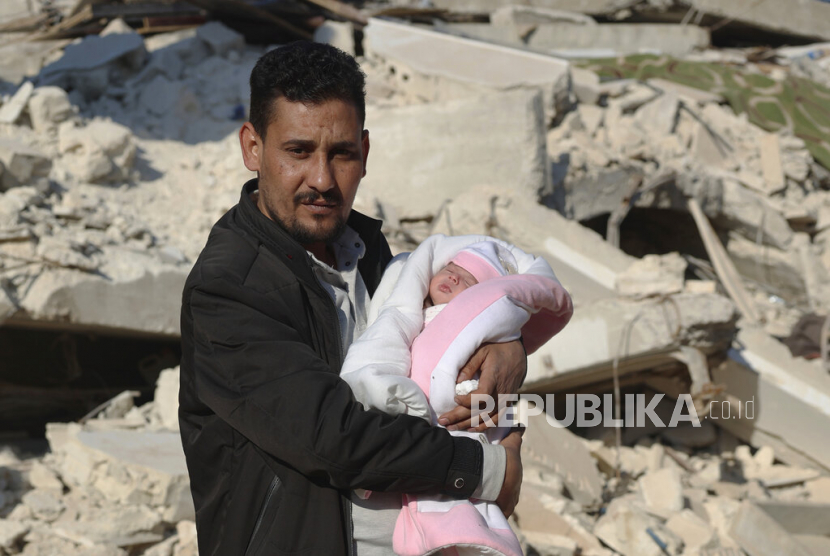  Khalil al-Sawadi menggendong Afraa, bayi perempuan yang lahir di bawah reruntuhan akibat gempa bumi yang melanda Suriah dan Turki, di kota Jinderis, provinsi Aleppo, Suriah, Senin (20/2/2023). Afraa meninggalkan rumah sakit dan telah pergi ke rumah barunya bersama keluarga bibi dari pihak ayah. OKI Serukan Lebih Banyak Bantuan untuk Korban Gempa Turki-Suriah