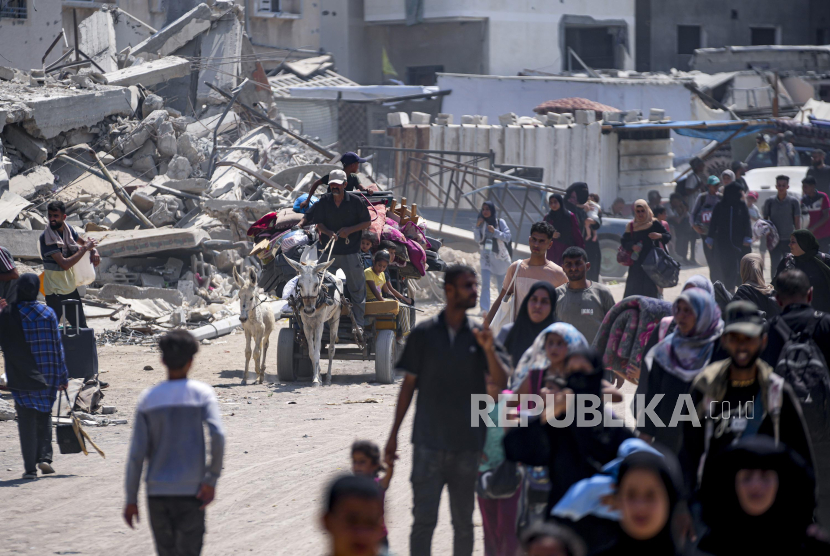 Warga Palestina berjalan untuk mengungsi akibat serangan Israel di Khan Younis, Jalur Gaza, Senin (22/7/2024). Ribuan warga di Khan Younis melarikan diri dari serangan udara dan operasi militer Israel. Kementerian Kesehatan di Gaza yang dikuasai Hamas melaporkan serangan Israel ke Khan Younis, selatan Jalur Gaza tersebut menewaskan 70 orang dan melukai lebih dari 200 lainnya.