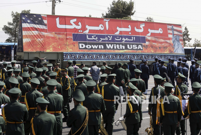 Spanduk anti-AS dibawa di atas truk selama parade militer memperingati dimulainya perang Irak-Iran 1980-88, di depan kuil mendiang pendiri revolusioner Ayatollah Khomeini, tepat di luar Teheran, Iran, Kamis , 22 September 2022.