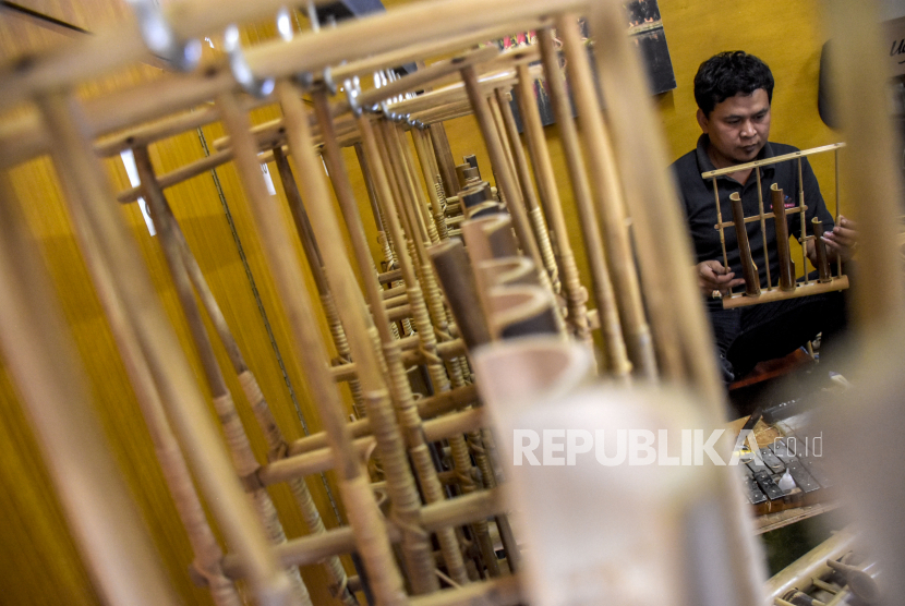 Perajin menyelesaikan pembuatan angklung. Pemkab Bogor menarik wisatawan dengan memadukan kesenian Angklung Gubrak.