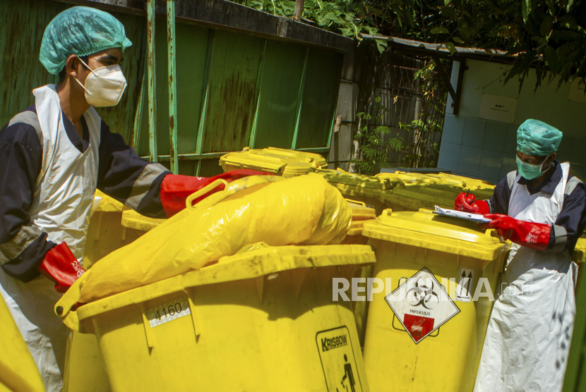 Petugas rumah sakit membawa wheeled bin atau wadah limbah beroda berisi limbah medis infeksius (ilustrasi)