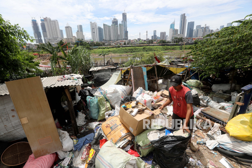 Seorang pria Indonesia mengumpulkan kotak karton yang tidak terpakai di sebuah permukiman kumuh di Jakarta, Indonesia pada 24 Maret 2021.