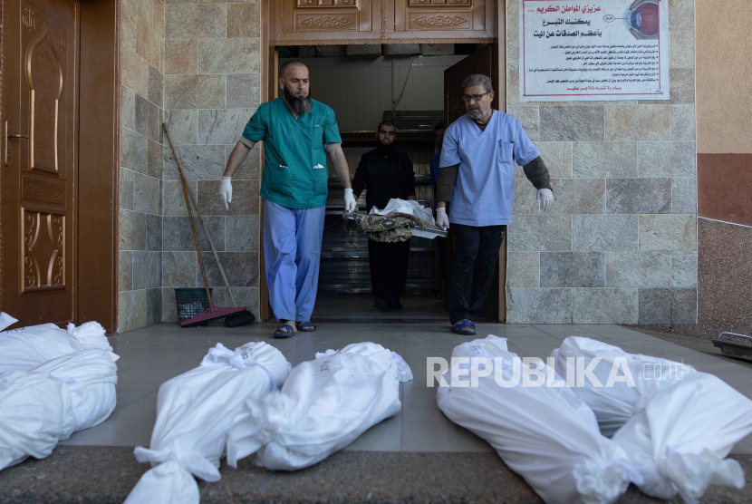 Staf kamar mayat di Rumah Sakit Nasser membawa jenazah anggota keluarga Abu Hatab yang terbungkus, di Khan Younis, Jalur Gaza selatan, (4/1/2024).