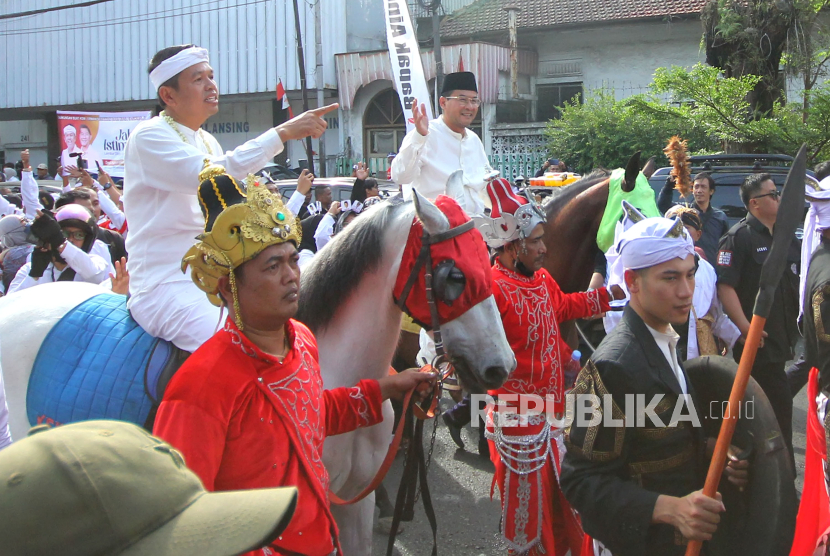 Pasangan Dedi Mulyadi dan Erwan Setiawan menunggang kuda menuju Kantor Komisi Pemilihan Umum (KPU) Jawa Barat (Jabar), Jalan Garut Kota Bandung, saat akan mendaftar Pilgub Jabar 2024, Selasa (27/8/2024). KPU Jabar sudah membuka pendaftaran pasangan Calon Gubernur dan Wakil Gubernur Jabar mulai 27-29 Agustus 2024.