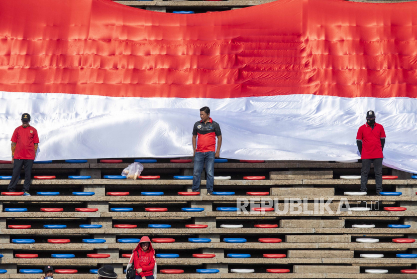 Suporter timnas sepak bola Indonesia U-22 membentangkan bendera Merah Putih raksasa saat pertandingan SEA Games 2023 Kamboja.