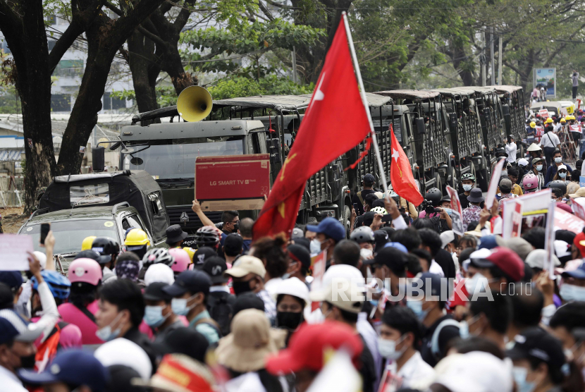  Demonstran tumpah ke jalan di sekitar kendaraan militer selama protes di luar Bank Sentral di Yangon, Myanmar, Senin (15/2).